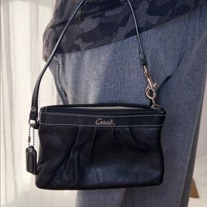 Coach EUC black leather wristlet, top stitched with tan interior w/hang tag.